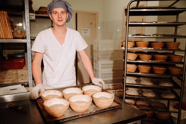 mutlu Baker kameraya bakarak ve gülümseyen ekmeği kalıplama