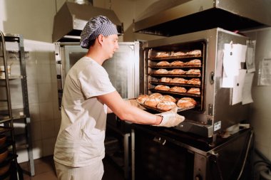 Taze pişmiş ekmek üretim, tam Tekdüzen holding tepsisinde yakışıklı baker