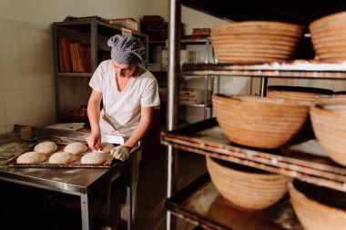 bir fırıncı ekmek hamur üzerinde el ile insizyon yapar. Bread.Bakery imalatı