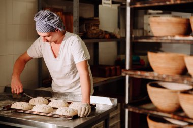 bir fırıncı ekmek hamur üzerinde el ile insizyon yapar. Bread.Bakery imalatı