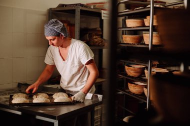 bir fırıncı ekmek hamur üzerinde el ile insizyon yapar. Bread.Bakery imalatı