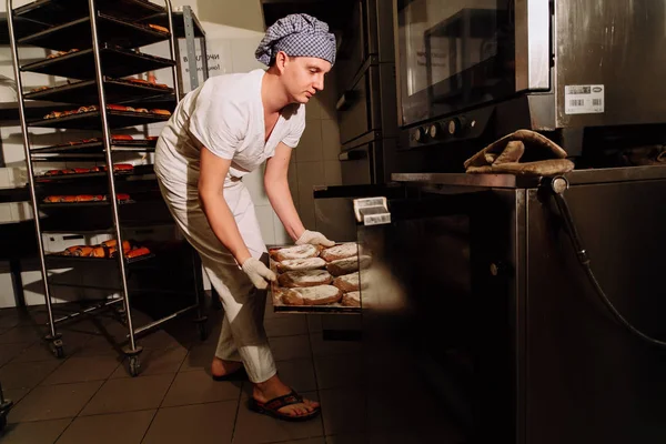 modern bir fırın fırında taze pişmiş ekmek alarak baker