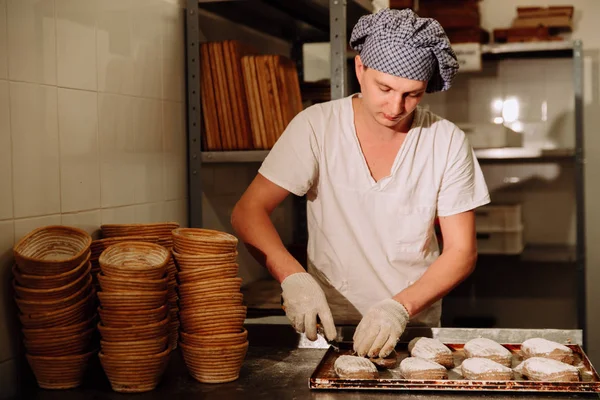 Ein Bäcker schneidet den Teig für das Brot manuell an. die Herstellung von Brot und Backwaren — Stockfoto