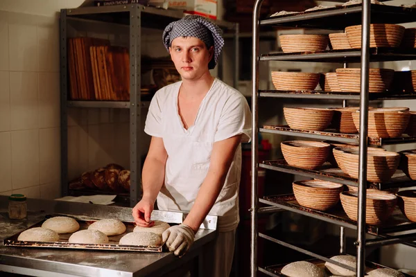 Un boulanger fait des incisions manuelles sur la pâte pour le pain. La fabrication du pain. Boulangerie — Photo