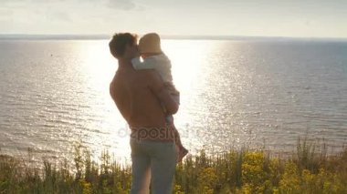 Baba kızı ellerinde uçurumun kenarında tutar