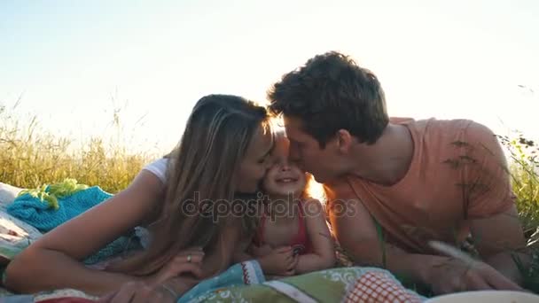 Familia feliz acostada en una manta y jugando alrededor — Vídeo de stock