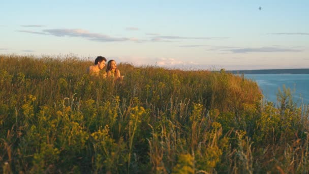 Lycklig familj titta på solnedgången på klippan — Stockvideo