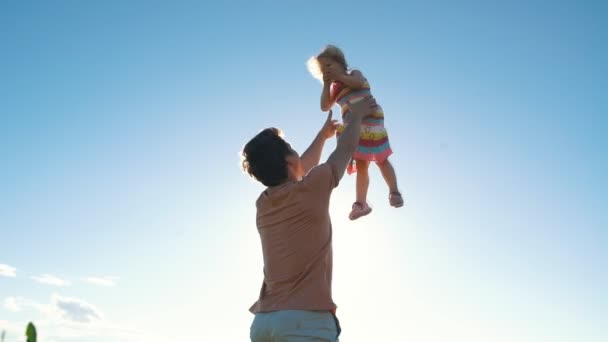 Père jetant son enfant en l'air sur la plage — Video