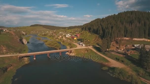 Vista aérea desde una altura sobre el río y el pueblo cerca de un bosque — Vídeo de stock