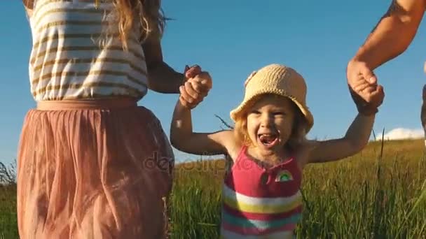 Счастливая семья, бегущая по полю — стоковое видео