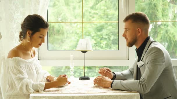 Flirting in a cafe. Beautiful loving couple sitting in a cafe enjoying in coffee and conversation — Stock Video