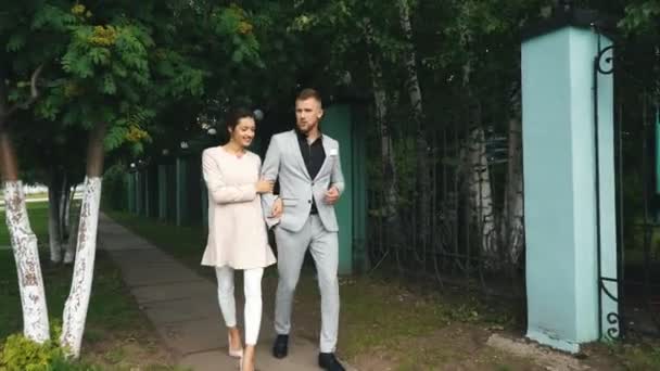 Молодая красивая пара, гуляющая в парке и говорящая — стоковое видео