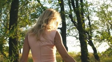 içinde bir güzel sarışın kadın ormanda yürür