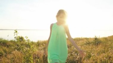 güzel sarışın bir alanda gün batımında yürüyüş