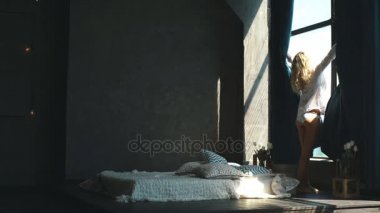 Sarışın genç kadın açık perdeleri