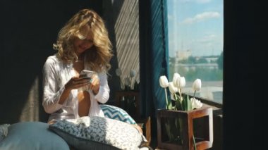 telefon ile yatakta genç güzel sarışın