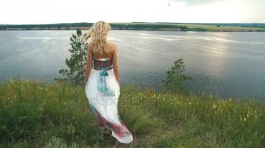 Kayalık Nehri'nin üzerinde duran genç sarışın kadın.