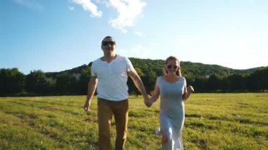 kaçarken el ele tutuşarak alanda aşık genç bir çift