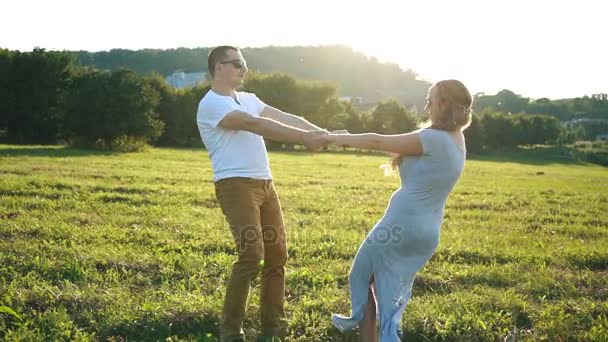 Feliz pareja girando en un campo — Vídeo de stock