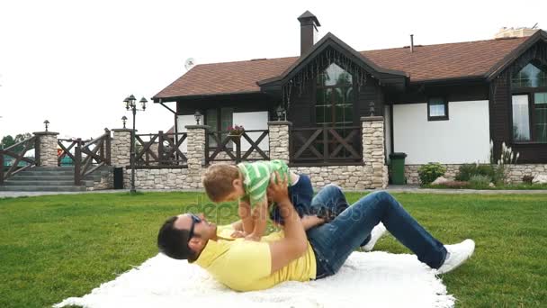 Happy father playing with son on lawn — Stock Video