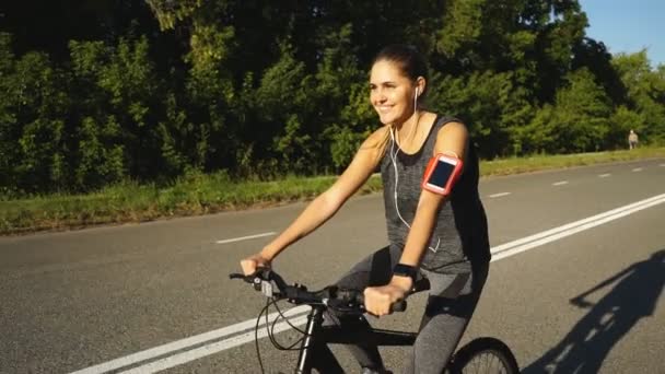 町、健康的なライフ スタイルの外の彼女の自転車に乗って幸せな若い女の子 — ストック動画