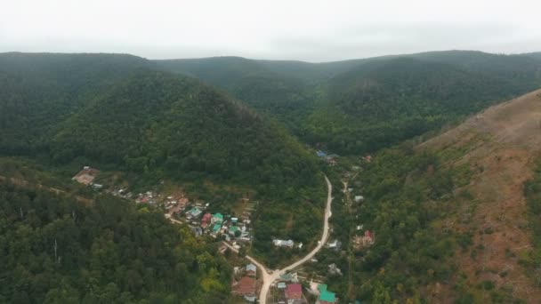 Vista aérea em uma pequena aldeia nas colinas — Vídeo de Stock