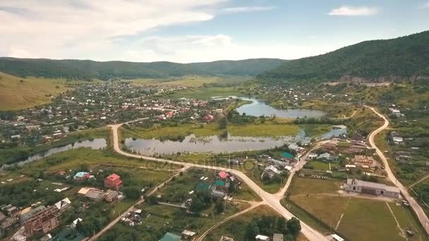 Vista aérea em uma pequena aldeia nas colinas — Vídeo de Stock