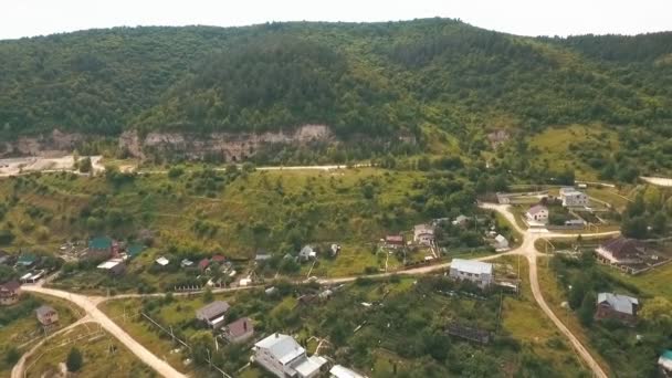 Vista aérea em uma pequena aldeia nas colinas — Vídeo de Stock