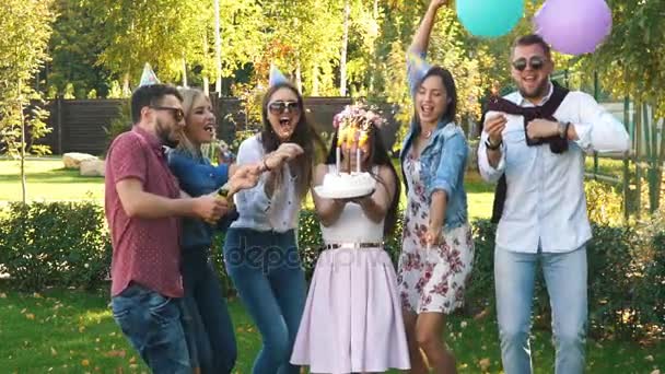 Um grupo de amigos em chapéu de festa e chifre de festa se divertindo e celebrando o aniversário — Vídeo de Stock