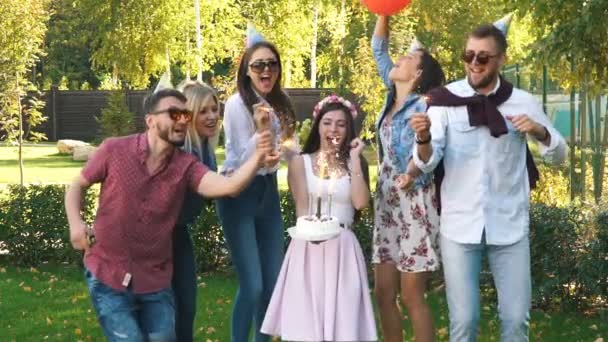 Un grupo de amigos en sombrero de fiesta y cuerno de fiesta divirtiéndose y celebrando el cumpleaños — Vídeo de stock