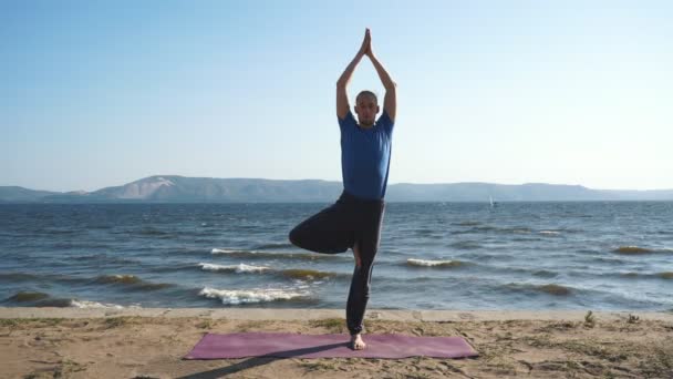 Manliga yogi gör yoga på kusten — Stockvideo