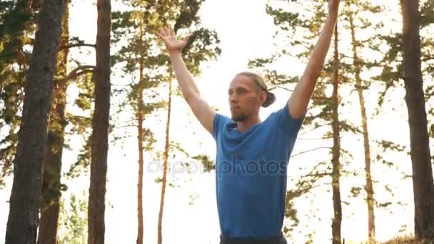 Jeune homme faisant du yoga dans les bois près de la rivière — Video