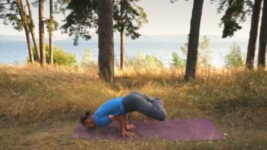 Nehrin yanında ormanda Yoga yapan genç erkek