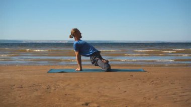 Adam pratik yoga gün batımında sahilde