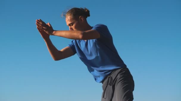 Сильный человек практикующий трудную позу йоги на пляже — стоковое видео