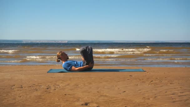 Jeune homme faisant étirement thoracique sur un rocher à la lumière du coucher du soleil — Video