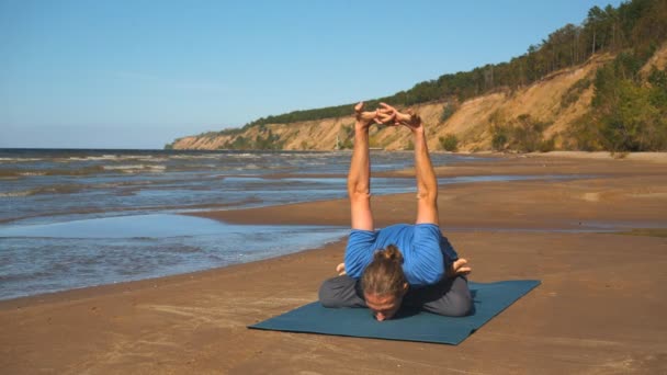 Giovane che fa stretching toracico su una roccia alla luce del tramonto — Video Stock