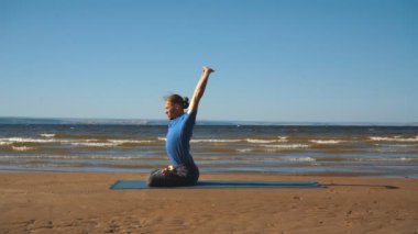 Bir kayaya günbatımı ışıkta göğüs germe yapan genç erkek