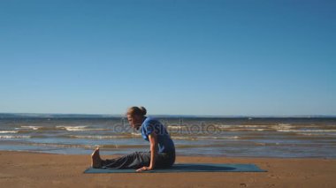 Gün batımı ışıkta bir plajda göğüs germe yapan genç erkek