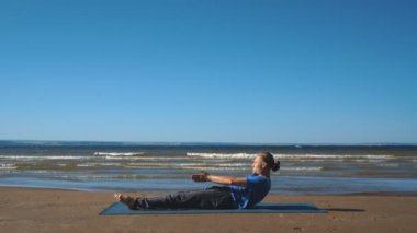 Gün batımı ışıkta bir plajda göğüs germe yapan genç erkek