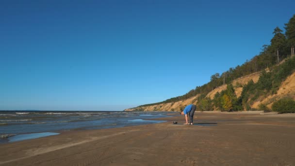 Fuerte hombre practicando difícil yoga pose en la playa — Vídeos de Stock