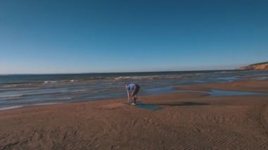 Havadan görünümü üzerinde bir adam sahilde yoga günbatımında yok.