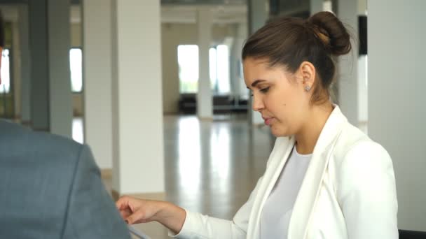 Hermosa mujer de negocios en una chaqueta blanca muestra tratado importante su colega en la oficina — Vídeos de Stock