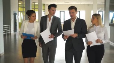 söz ve ofis lobisinde yürüme dört iş adamları