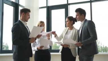 ofis lobisinde konuşurken dört iş adamları