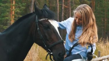 Sevgi ve anlayış kız ve at arasında. Kızıl saçlı kız ve ormandaki kahverengi at.