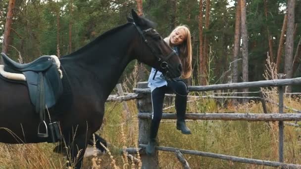 Amour et compréhension entre fille et cheval. Fille rousse et cheval brun dans la forêt . — Video