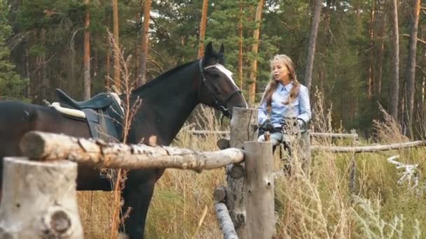 Láska a porozumění mezi dívky a koně. Zrzka dívka a hnědé koně v lese. — Stock video