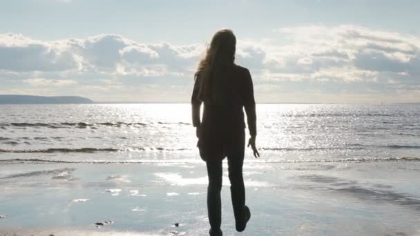 Chica en la playa levanta sus brazos al cielo — Vídeos de Stock