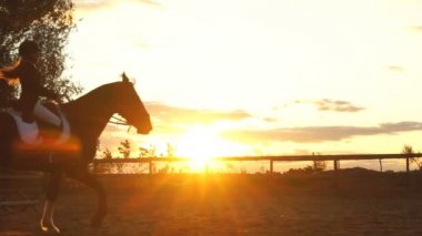 Günbatımında bir binicilik bir kız silüeti